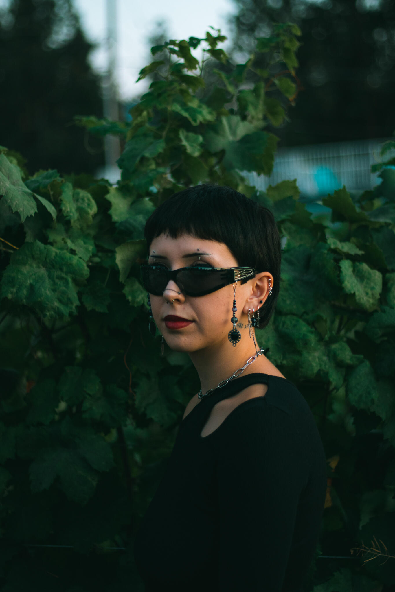 The Vineyards at Frequency Sound 528 A woman with sunglasses and a black top, showcasing a chic and modern look in a vineyard.