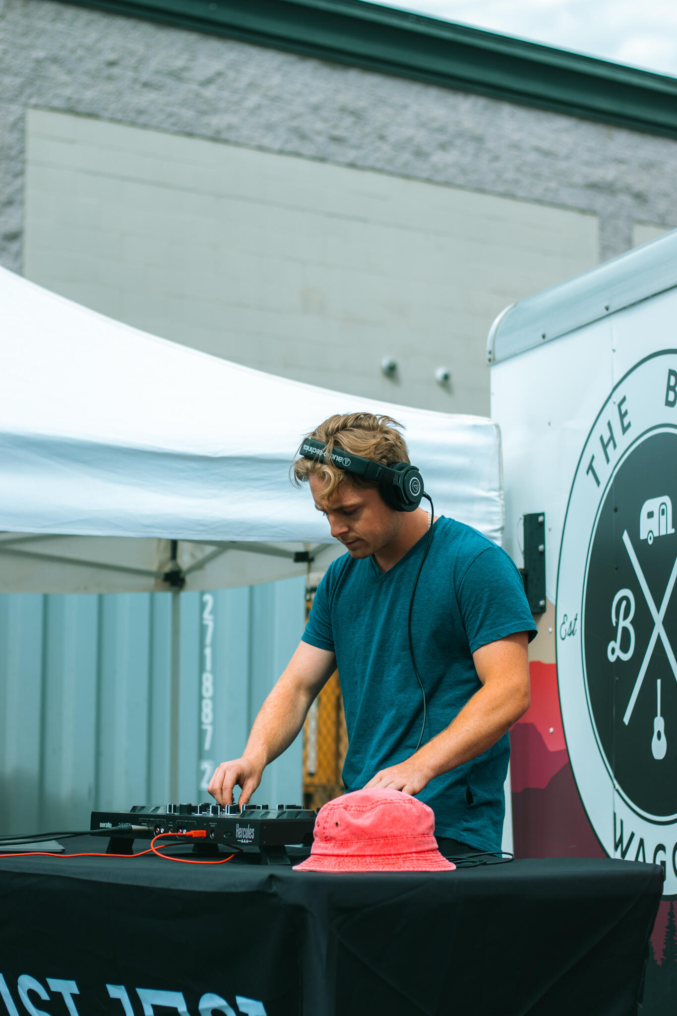 Never Ending Summer A man is engaged in mixing music at a DJ table, showcasing his skills as colorful lights create a lively ambiance around him.
