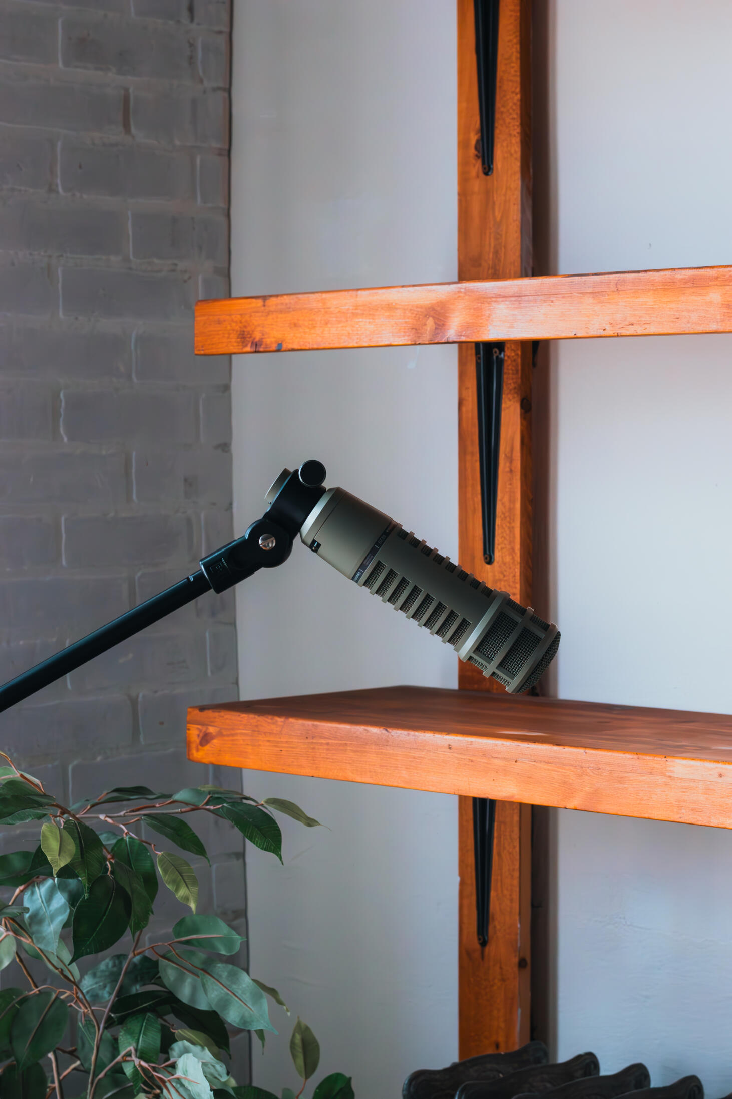 Vault 22 Multiple high-quality MIDI pianos and devices used to produce, mix, and master different music tracks, featured on a clean wood shelf with light shining on them.