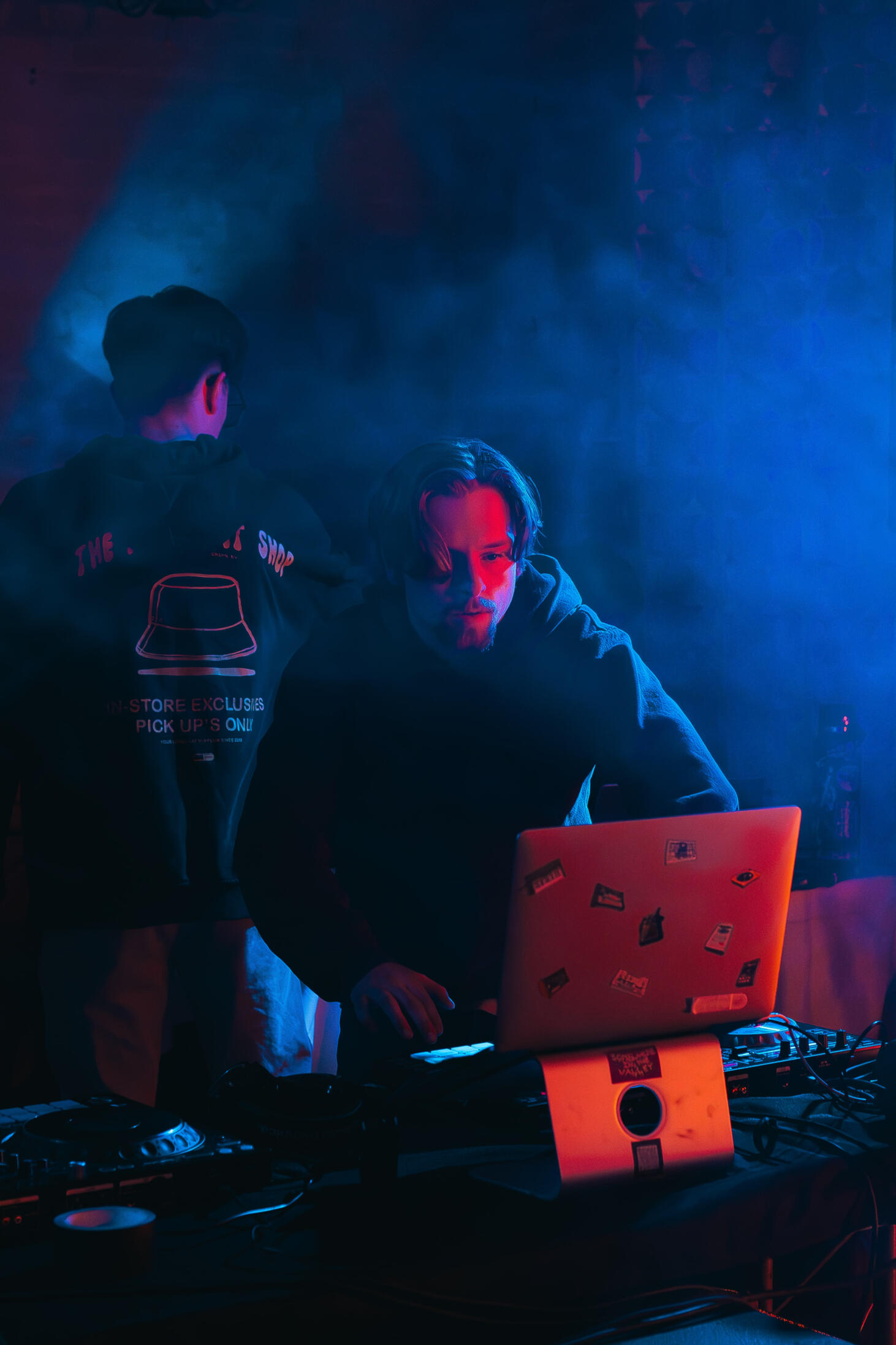 Vault 22 Multiple high-quality MIDI pianos and devices used to produce, mix, and master different music tracks, featured on a clean wood shelf with light shining on them.